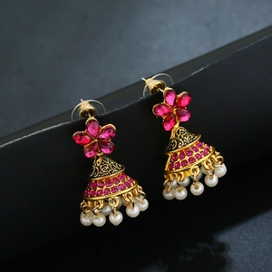 Gros plan détaillé de boucles d'oreilles Jhumka vintage avec pierres roses et perles