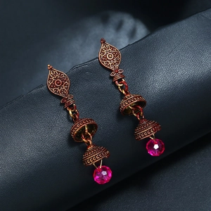 Dettaglio di orecchini bohémien in bronzo con perline di cristallo rosa vivace
