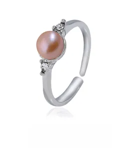 Vue détaillée d'une bague argentée ajustable avec perle rose et petits strass brillants