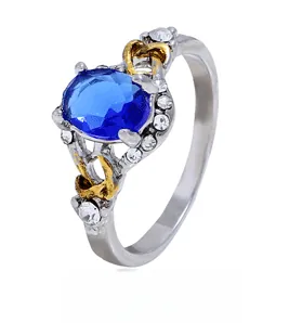 Détail d'une bague rétro avec pierre bleue, touches dorées et gravures en forme de cœur