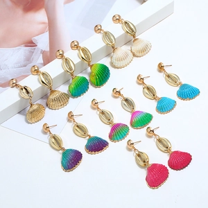 Detail view of colorful seashell earrings collection with golden cowrie shell studs
