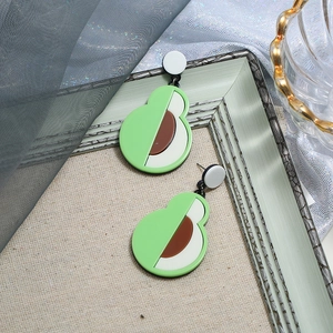 Detail von grünen Avocado-Ohrringen mit Harztextur auf einem Vintage-Rahmen