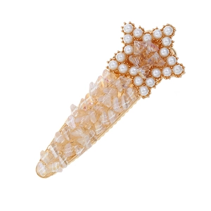 Close-up of star-shaped hair clip with pearls and champagne crystals on gold alloy