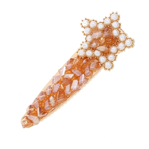 Star shaped hair clip with amber crystals and pearl outline on golden base