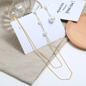 Elegante asymmetrische lange kwastjes oorbellen met witte parels en gouden ketting