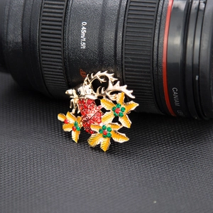 Macro shot of Christmas reindeer brooch with red rhinestones and gold alloy details