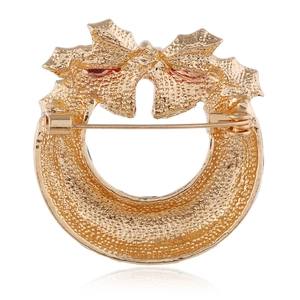 Broche couronne de Noël dorée avec nœud, montrant l'épingle et le fermoir arrière