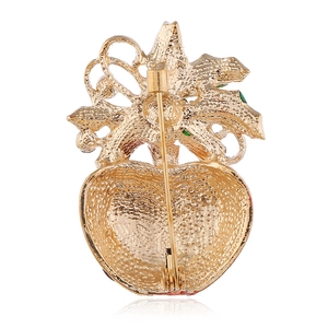 Back view of a gold Christmas apple brooch with red and green enamel and safety pin