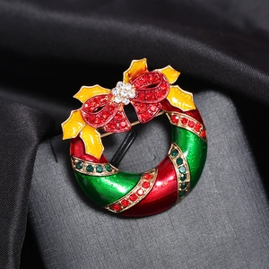 Broche couronne de Noël exquise avec nœud rouge et strass colorés sur fond sombre chic