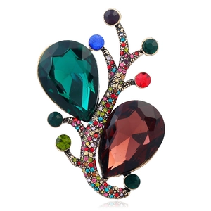 Vintage gold brooch with large green and red gemstones and colorful rhinestones