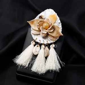 Bohemian acrylic flower brooch with white tassels and shells on black silk background