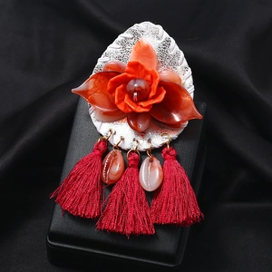 Ethnic acrylic floral brooch with red tassels and shell charms on black silk