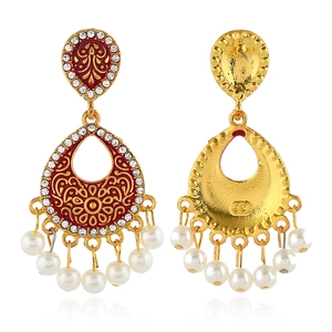 Detail van bohemien gouden oorbellen met rood emaille patroon en parelkwastjes