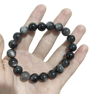 Pulsera de cuentas de obsidiana plateada natural pulida para hombres y mujeres en mano