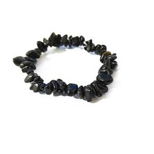 Dettaglio di perline irregolari in pietra naturale nera su bracciale elastico