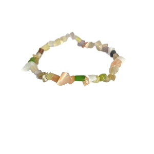 Dettaglio di un bracciale con pietre di cristallo naturali irregolari in vari colori