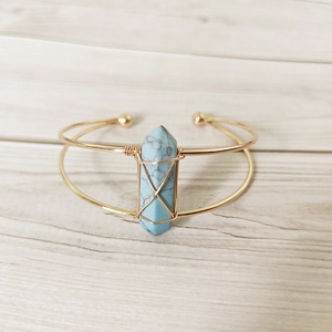 Detail of handmade gold wire-wrapped open cuff featuring a hexagonal blue turquoise stone