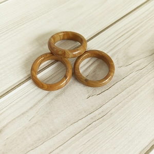 Detailed view of three 6mm natural agate rings with wood grain patterns stacked on wood