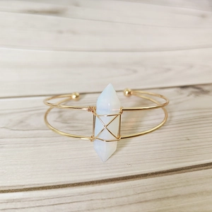 Handmade gold plated bangle with hexagonal opalite crystal on wooden background