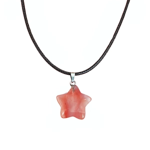 Gros plan d'un pendentif étoile en pierre naturelle rose sur un cordon noir