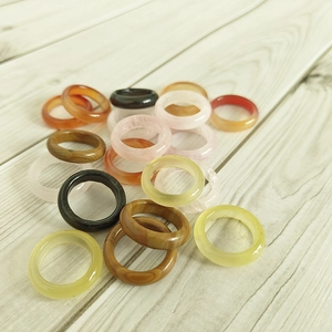 Natural agate rings 6mm colorful gemstone bands displayed on a light wooden background