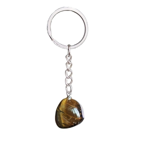 Détail d'un pendentif en pierre d'oeil de tigre irrégulière sur un porte-clés en métal