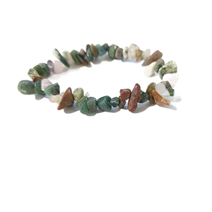 Dettaglio macro di pietre naturali irregolari multicolori su bracciale elastico