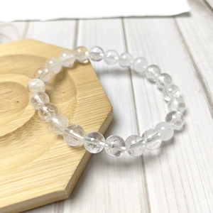 Bracelet minimaliste en cristal blanc naturel à perles rondes sur plateau bois