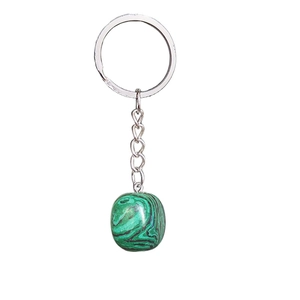 Porte-clés en pierre de malachite verte avec anneau en métal argenté sur fond blanc