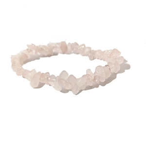 Bracciale elastico da donna con pietre di quarzo rosa naturali irregolari su sfondo bianco