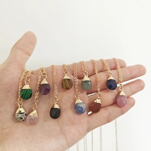 Natural teardrop crystal necklaces in rose quartz and amethyst held by hand