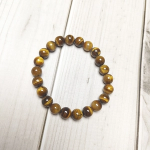 Macro shot of 8mm tiger eye stone beads on a stretch bracelet with polished texture