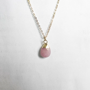 Detail shot of faceted pink quartz waterdrop pendant on elegant golden link chain