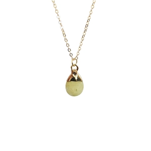Detail of light green teardrop crystal pendant with gold edge on thin necklace chain