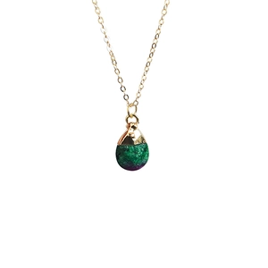 Close-up of teardrop natural stone pendant with gold plating and fine link chain