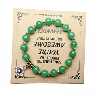Detail von grünem Aventurin Armband mit Goldperlen und Evil-Eye-Anhänger auf Geschenkkarte