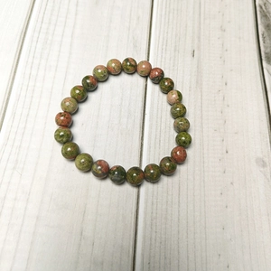 Close-up of 8mm natural Unakite stone beads with unique green and pink textures