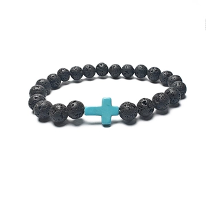 Detail of porous black lava stone beads and blue turquoise cross charm on elastic bracelet