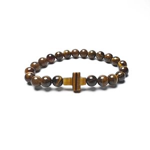 Detailed close-up of tiger eye beaded bracelet featuring a cross charm on white background