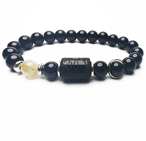 Macro del bracciale di perle nere con incisione a rinoceronte e perla traslucida