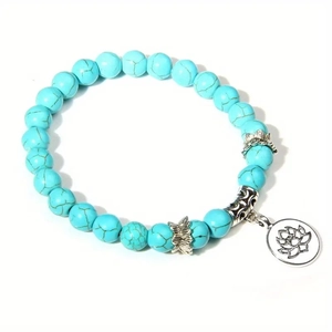 Nahaufnahme der himmelblauen Türkisperlen mit silbernem Lotus-Anhänger am Armband
