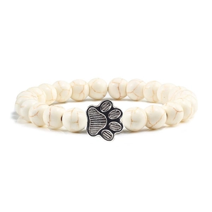 Bracciale di perle di turchese bianco con ciondolo a zampa d'argento su sfondo bianco