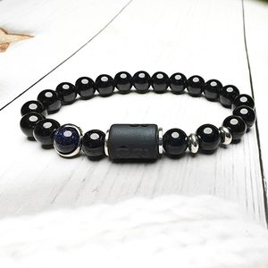 Dettaglio del bracciale con perline nere e pietra blu stellata con inserti in argento