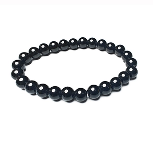 Detailweergave van de gepolijste zwarte stenen kralenarmband met glanzend oppervlak