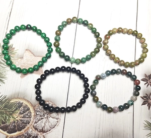 Detailopname van vijf elastische armbanden met tijgeroog- en malachietkralen set