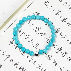 Macro d'une perle Yin Yang et pierres turquoises sur un fond de calligraphie d'art