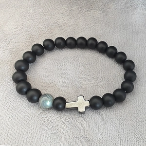 Matte black beaded bracelet with silver cross pendant and grey stone bead on velvet