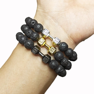 Trio of volcanic lava stone bracelets with gold, silver, and black dumbbell charms
