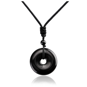 Gros plan d'un pendentif Ping'an en obsidienne noire avec collier en corde tressée noire