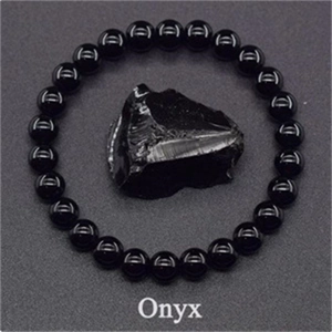 Macro view of polished 8mm black onyx bead bracelet with raw natural stone element